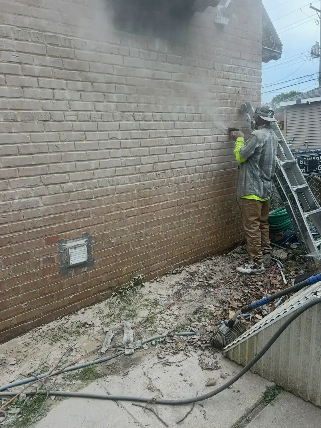 Dust coming off a brick elevation as the mortar joints are ground out